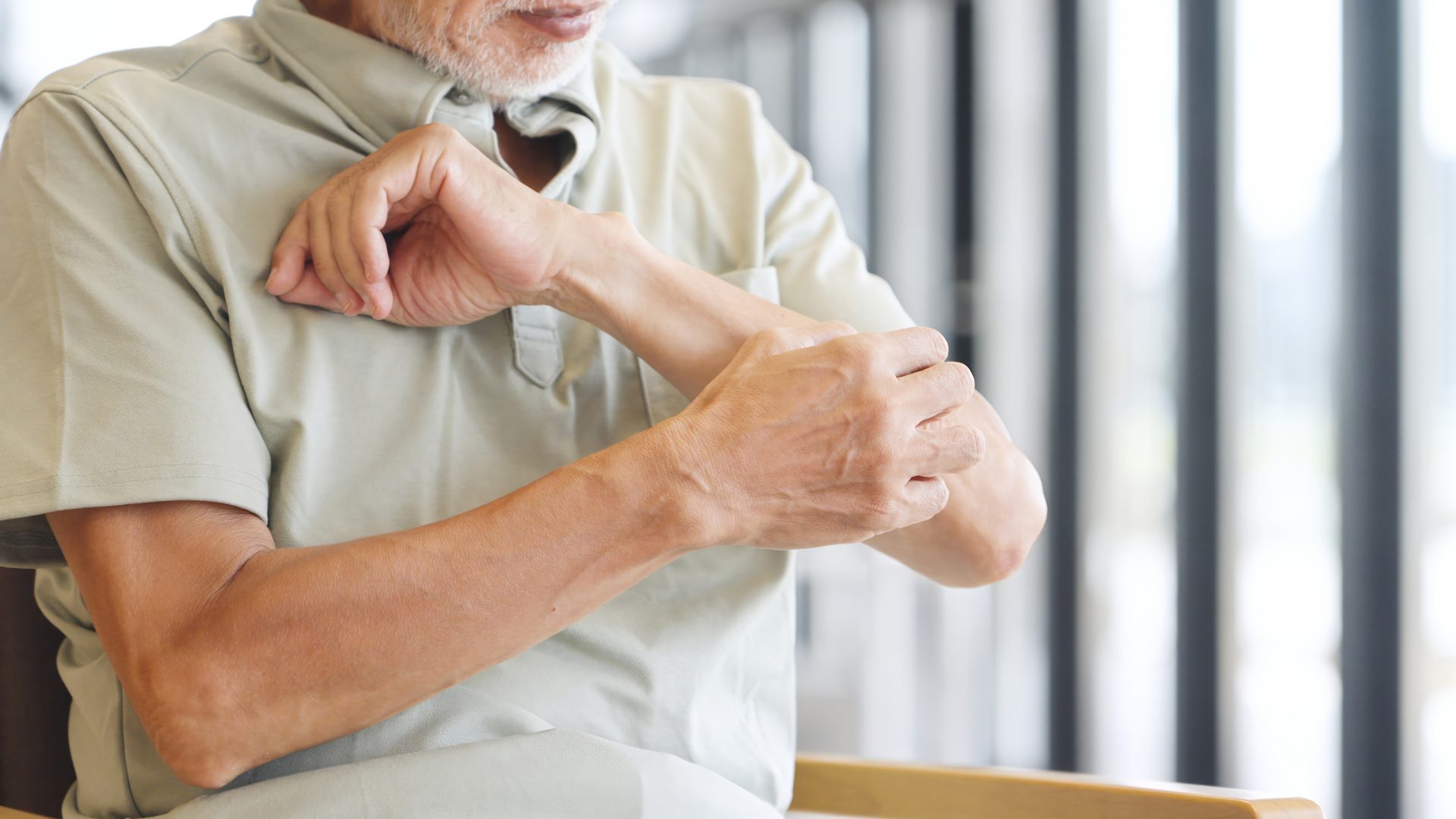 uomo si gratta braccio per prurito