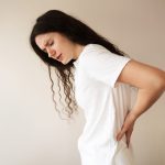 giovane donna con dolore lombare