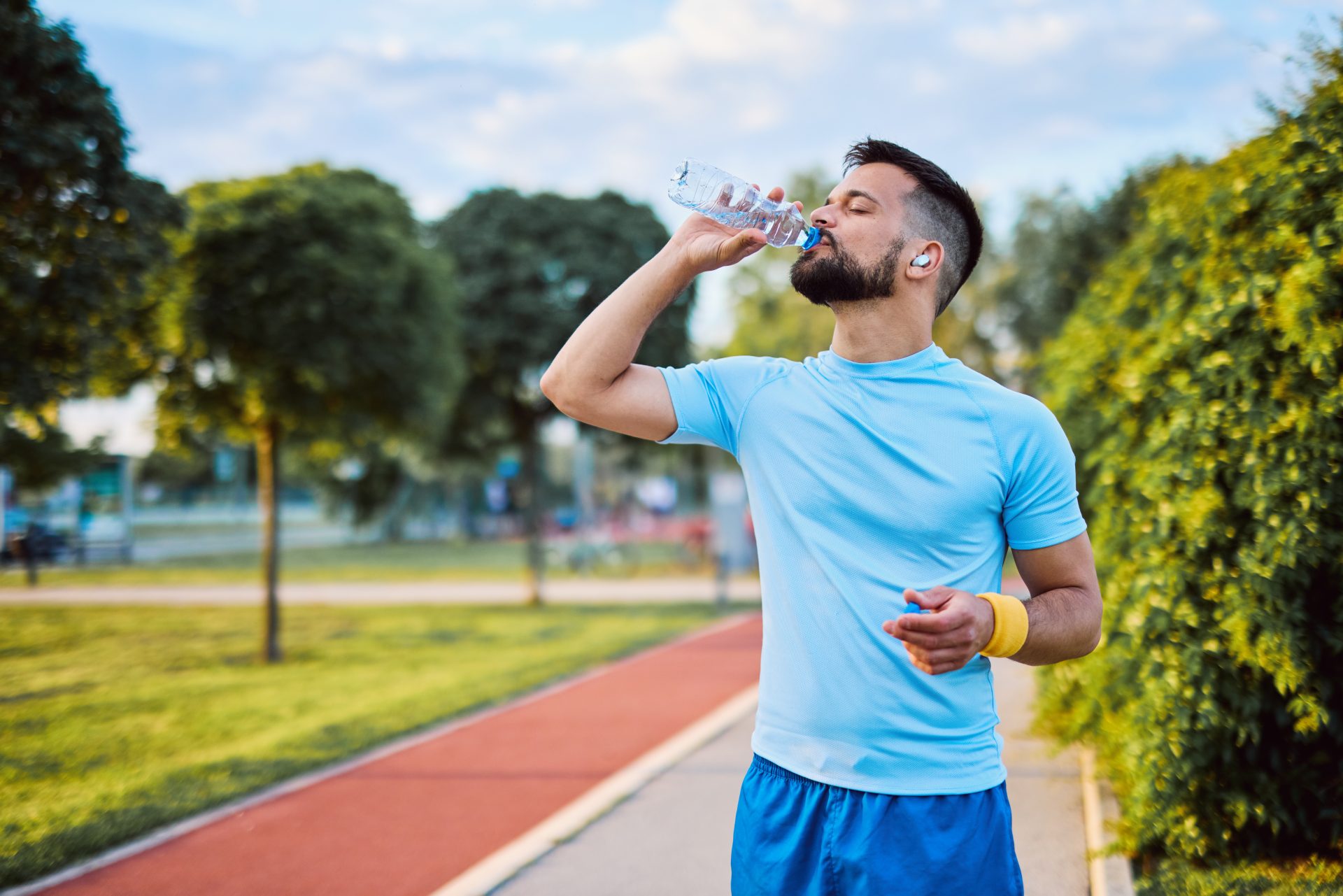 giovane uomo beve dopo corsa al parco