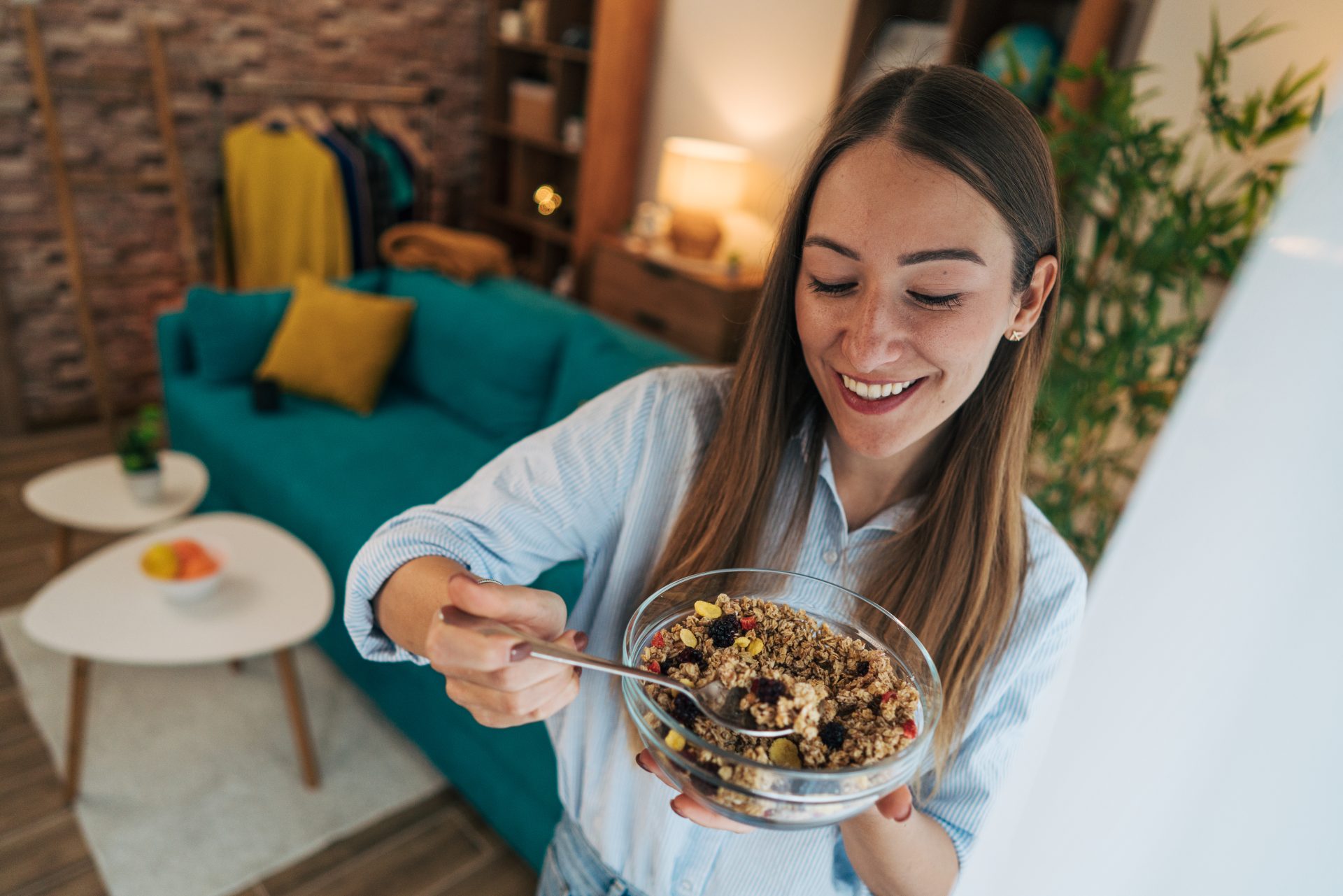 giovane donna mangia cereali da una ciotola