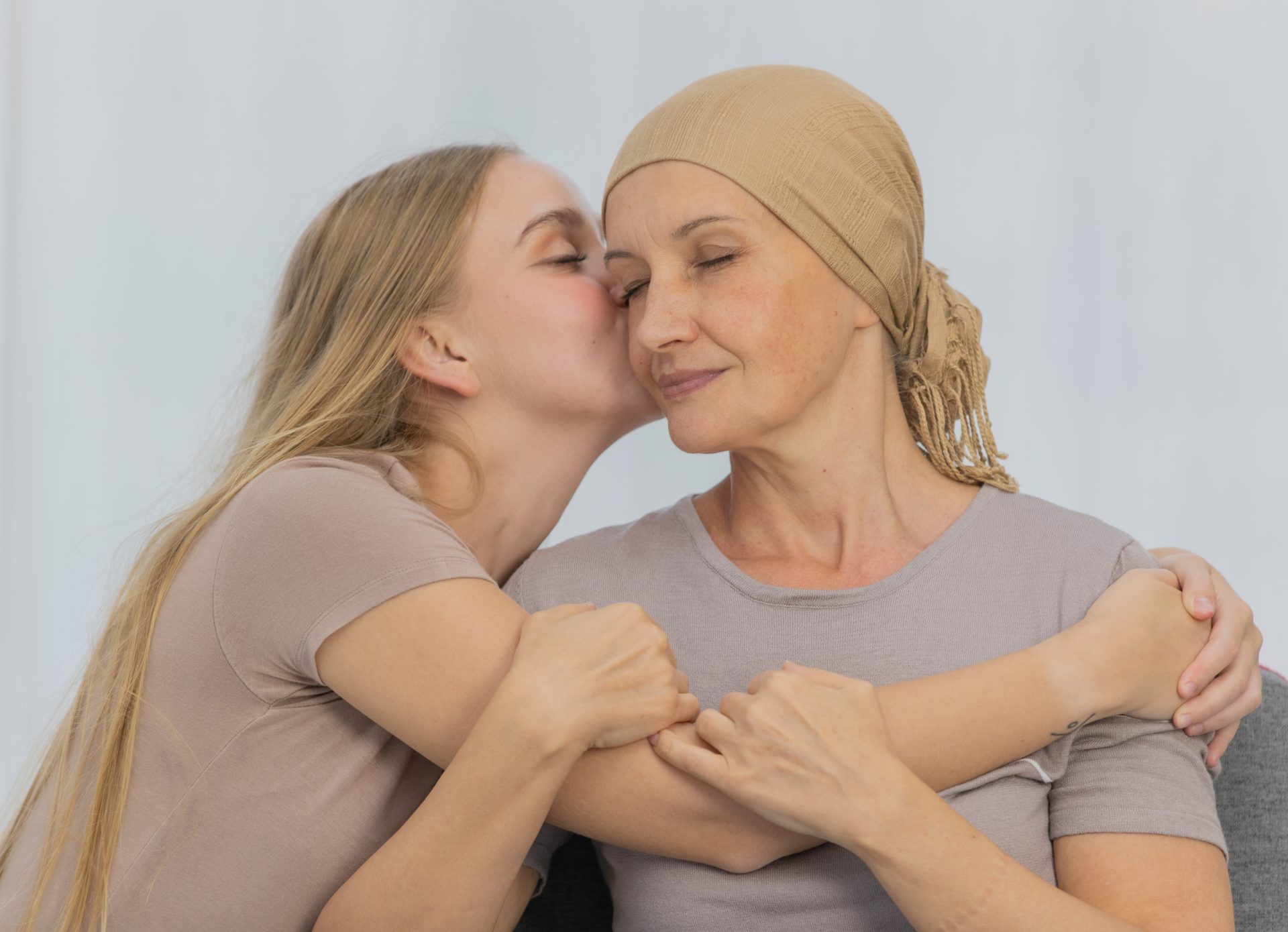 ragazza abbraccia madre malata di cancro