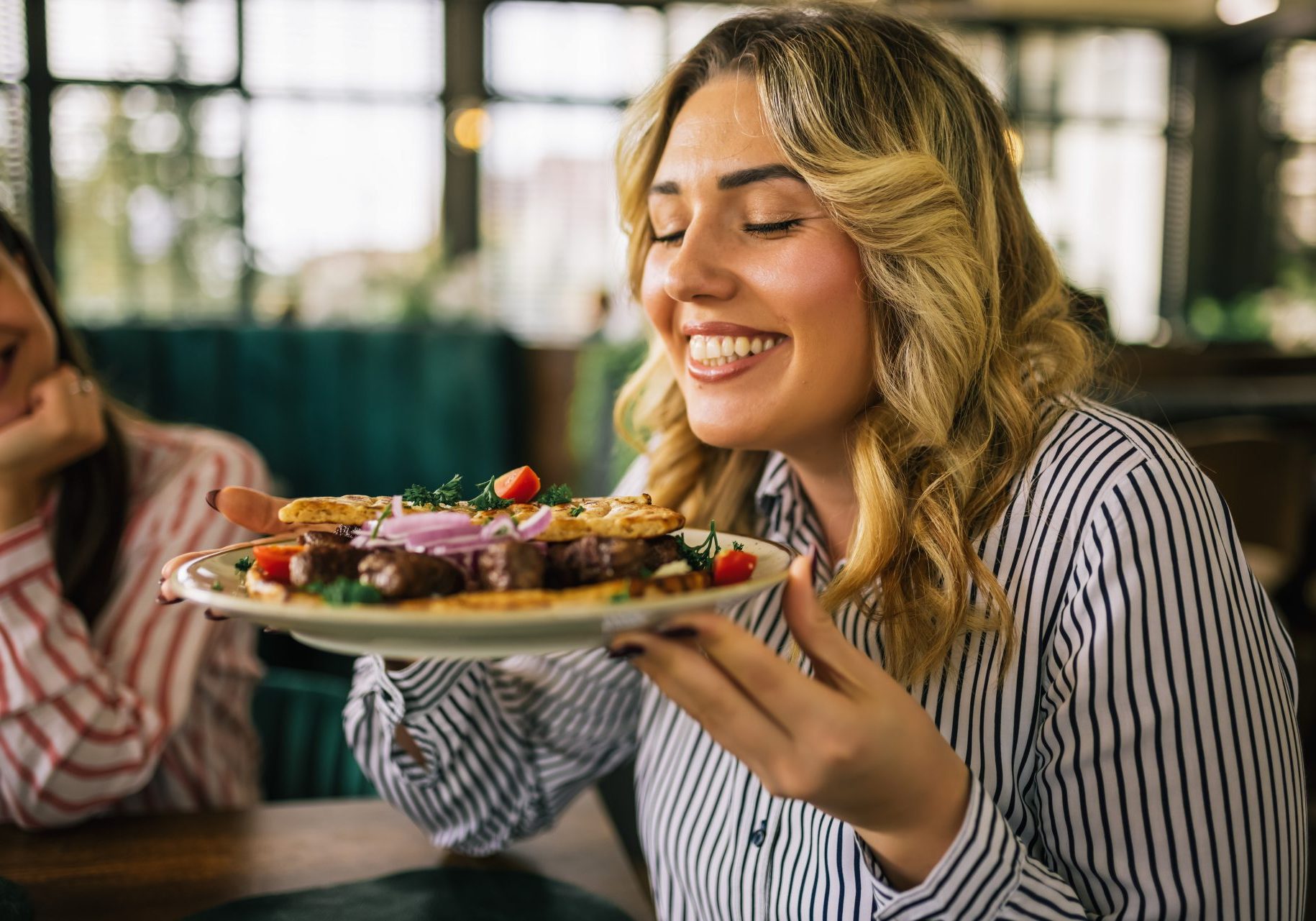 vitamina-b12_cover giovane donna sorridente tiene piatto con bistecca