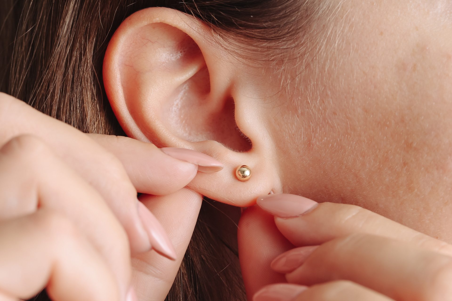 donna mostra orecchino dorato