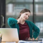 donna alla scrivania con dolore al collo