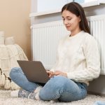 giovane donna seduta con le spalle al termosifone