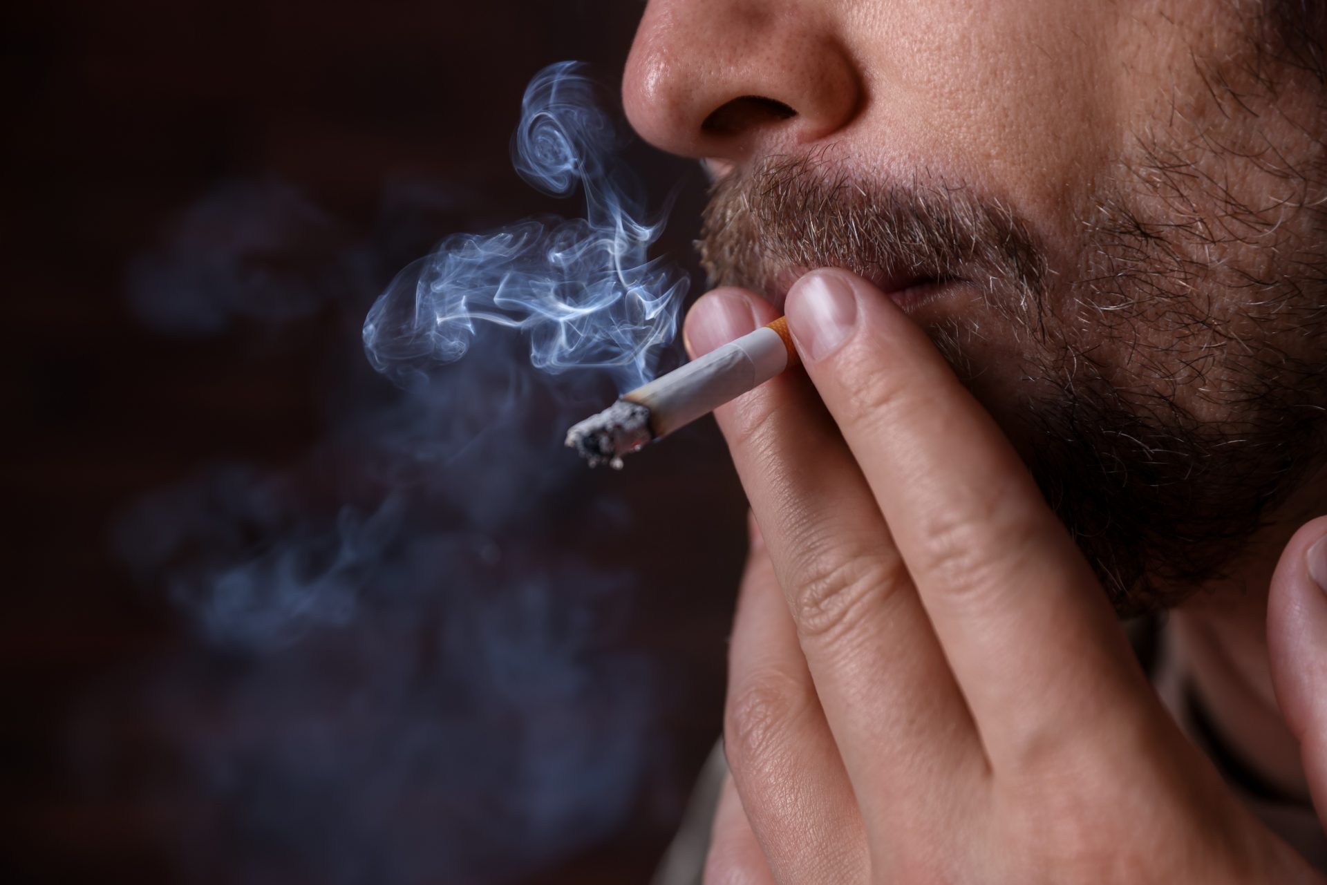 uomo fuma sigaretta