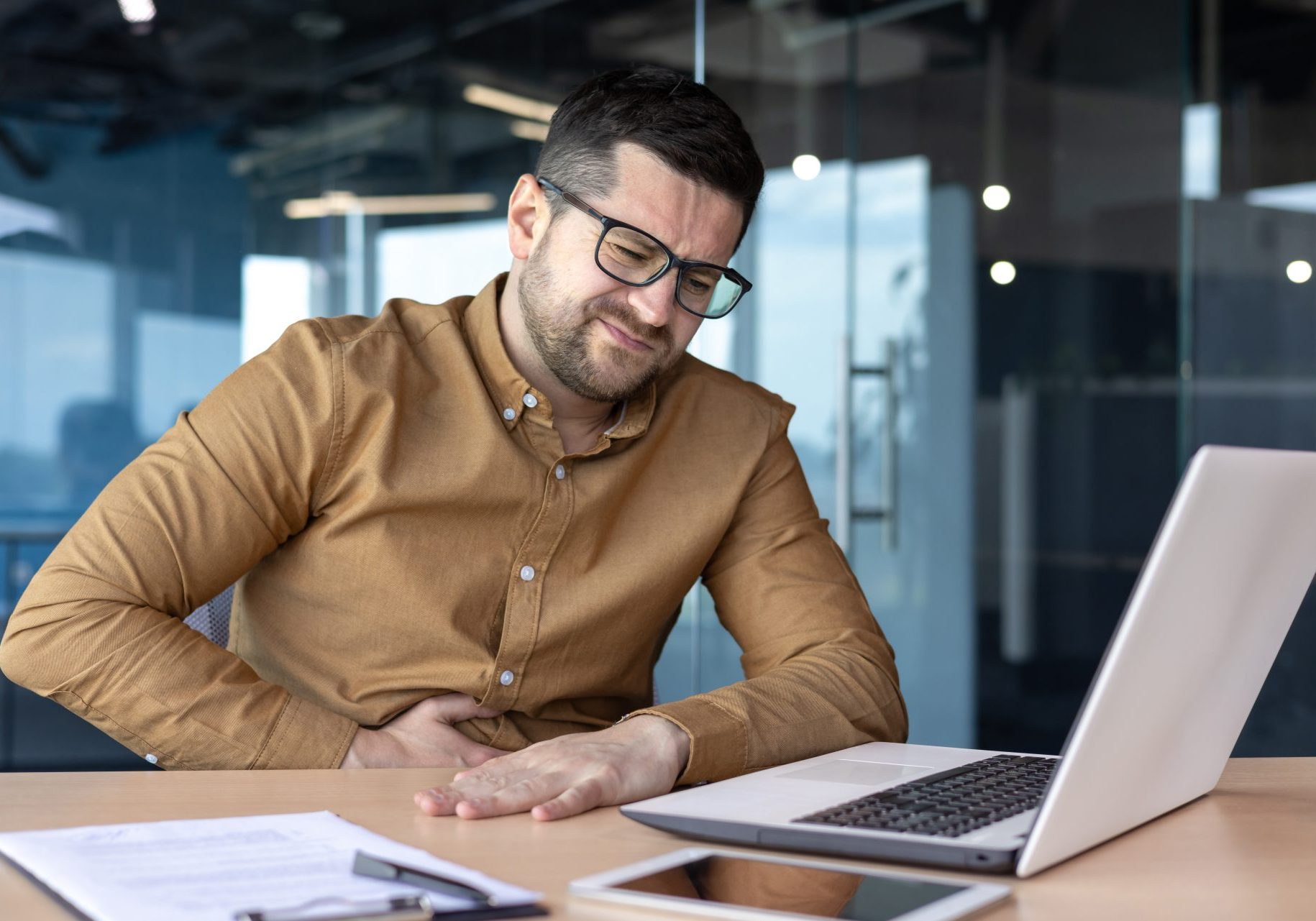 uomo con mal di stomaco a lavoro