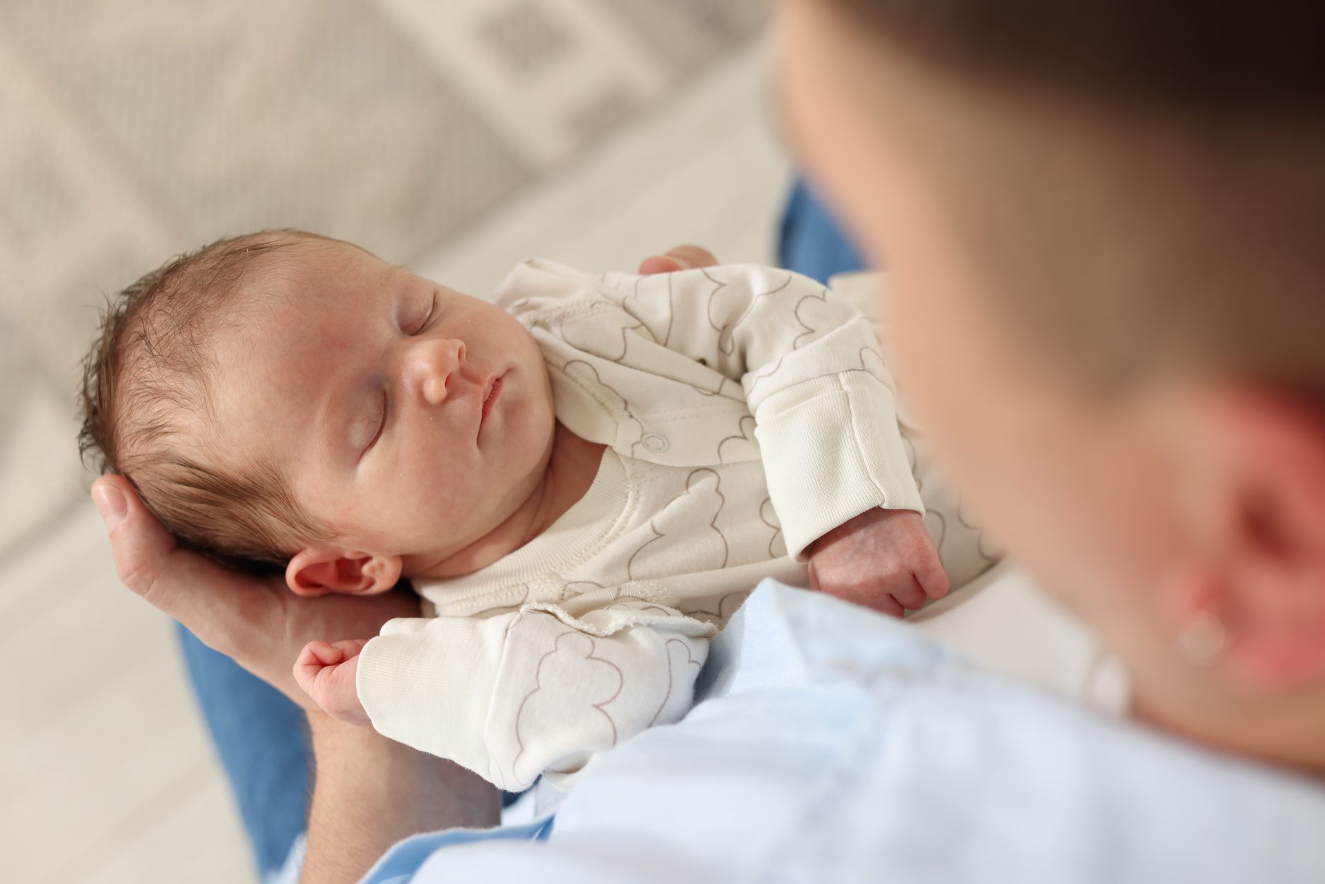 neonato dorme in braccio al padre