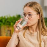 ragazza beve bicchiere d'acqua