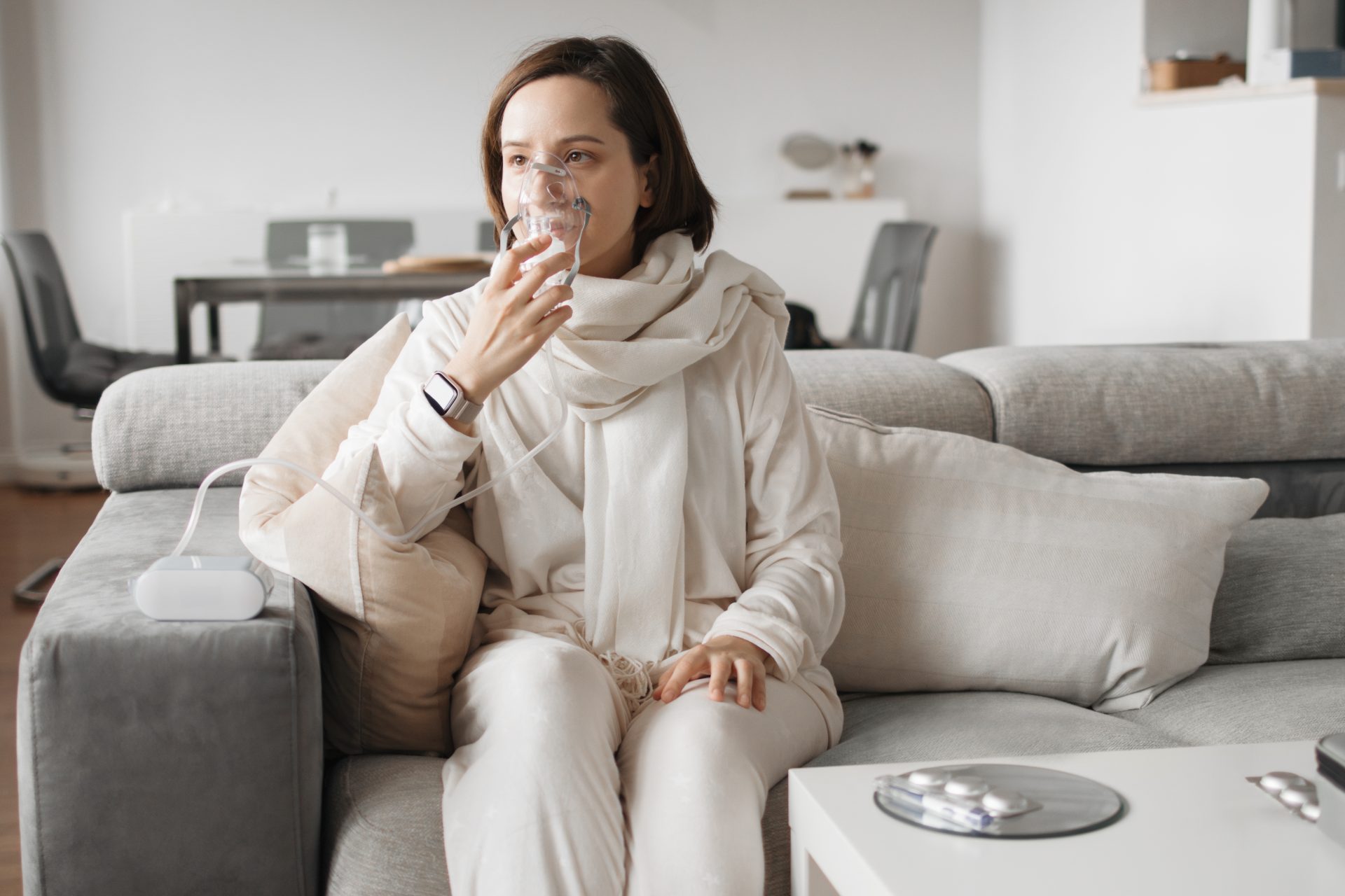 donna fa terapia con aerosol seduta sul divano
