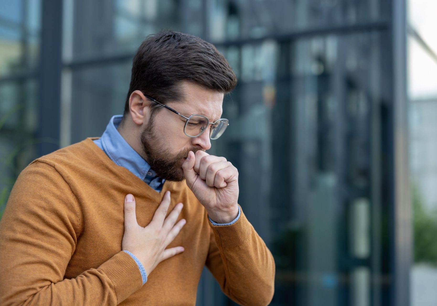 bronchite-sintomi_cover giovane uomo tossisce con mano al petto