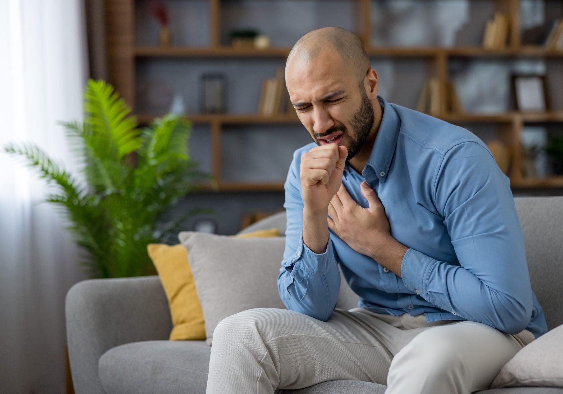 bronchite_cover uomo seduto sul divano tossisce