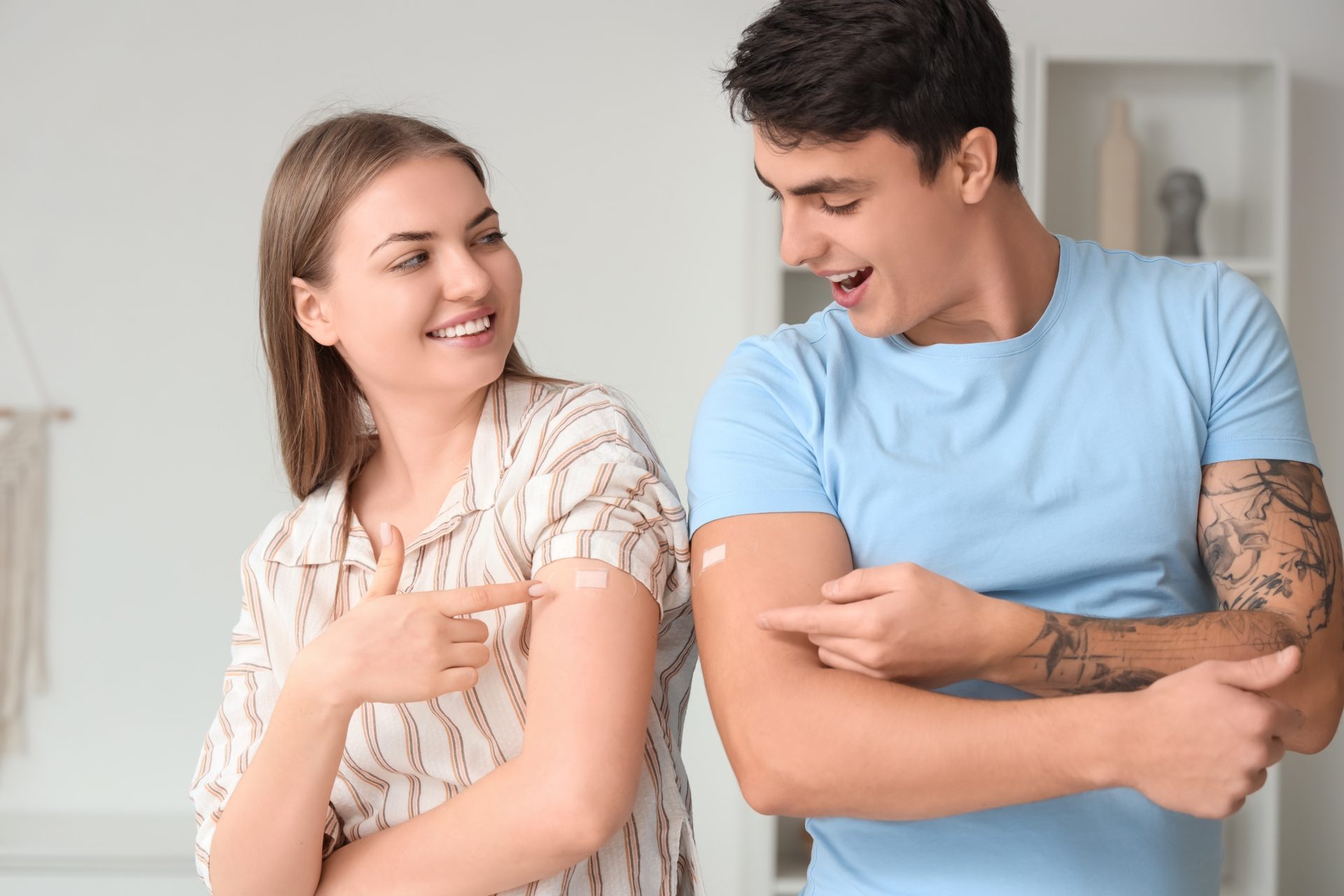 ragazza e ragazzo mostrano cerotto su braccio post vaccino