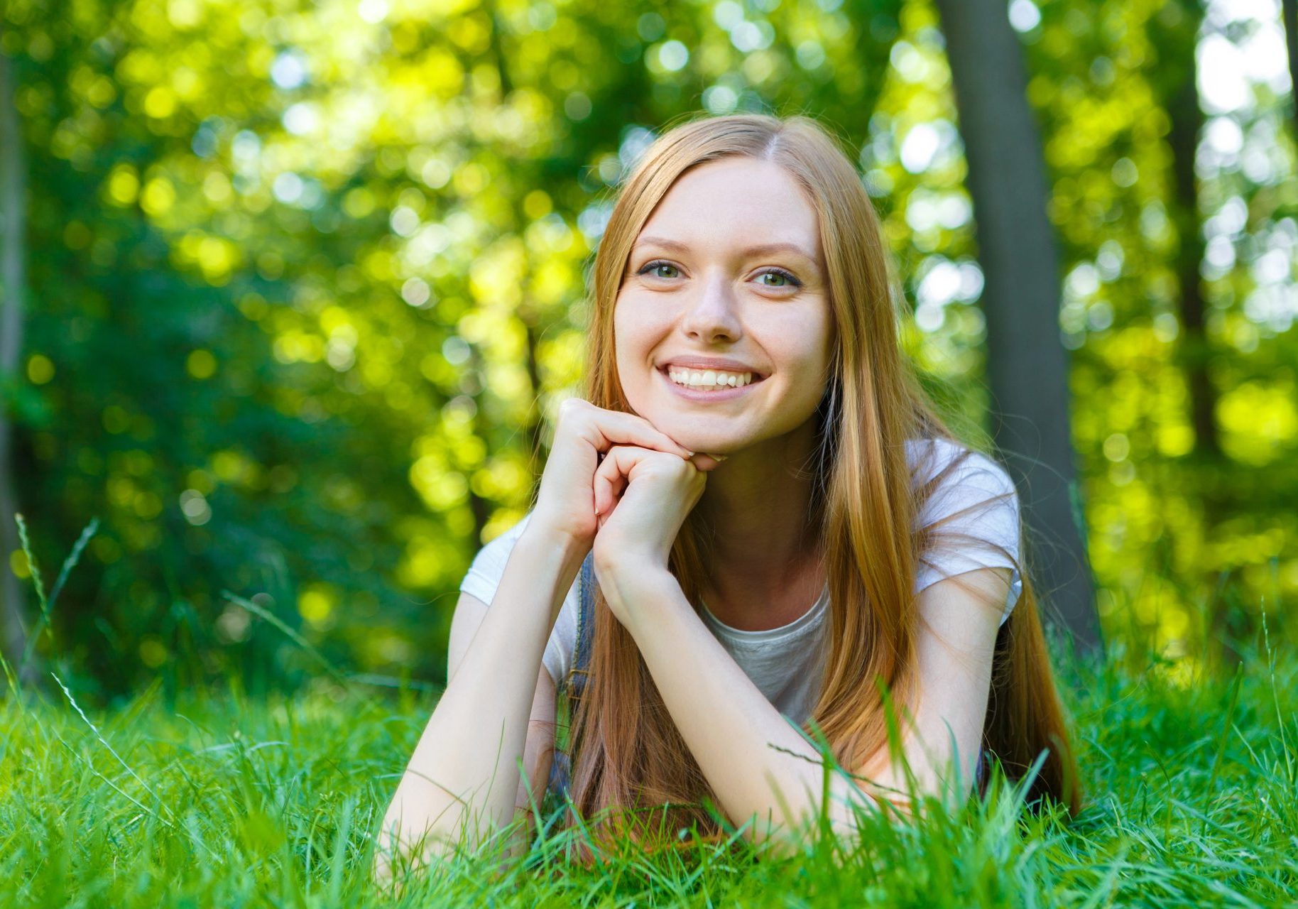 giovane ragazza sorridente distesa su prato