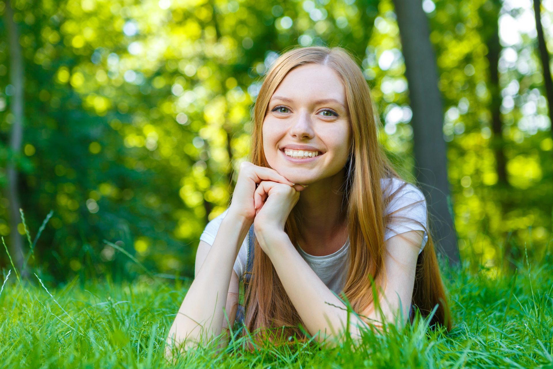giovane ragazza sorridente distesa su prato