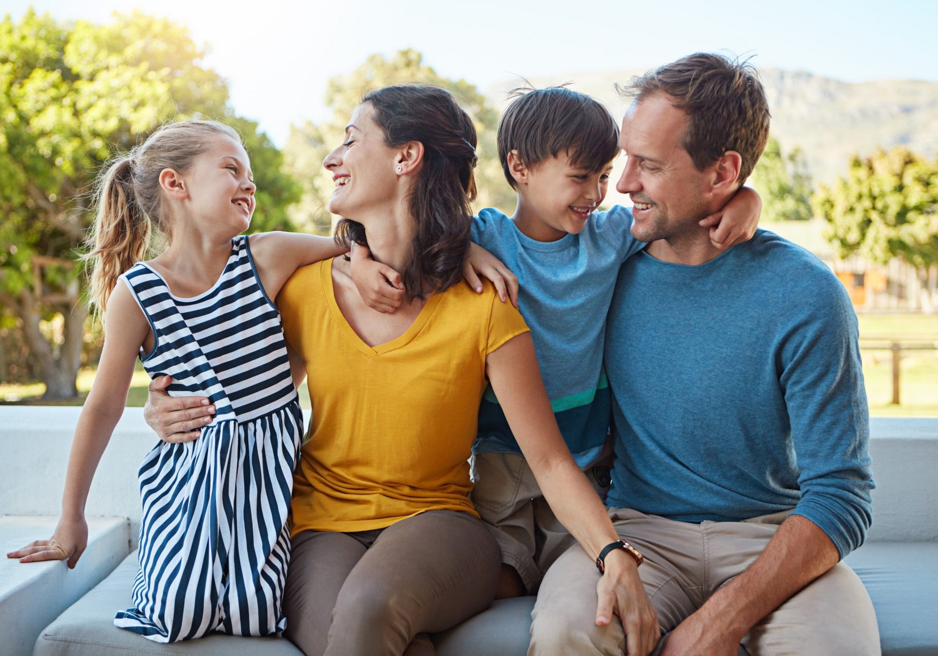 famiglia di madre, padre, bambino e bambina abbracciati