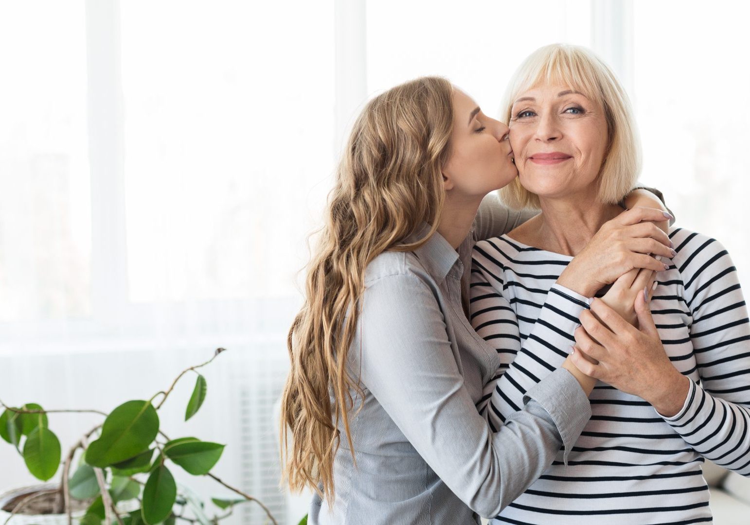 ragazza abbraccia e dà bacio sulla guancia alla madre