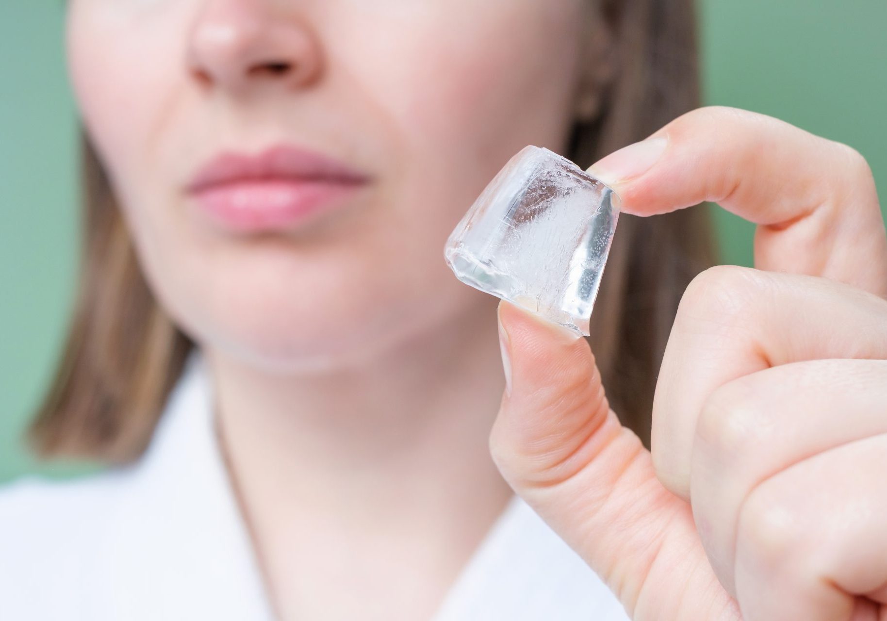 ustioni-da-freddo_cover donna tiene cubetto di ghiaccio tra le dita