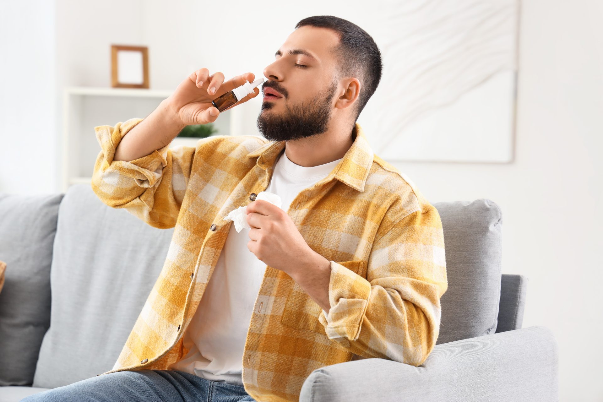 giovane uomo utilizza spray nasale