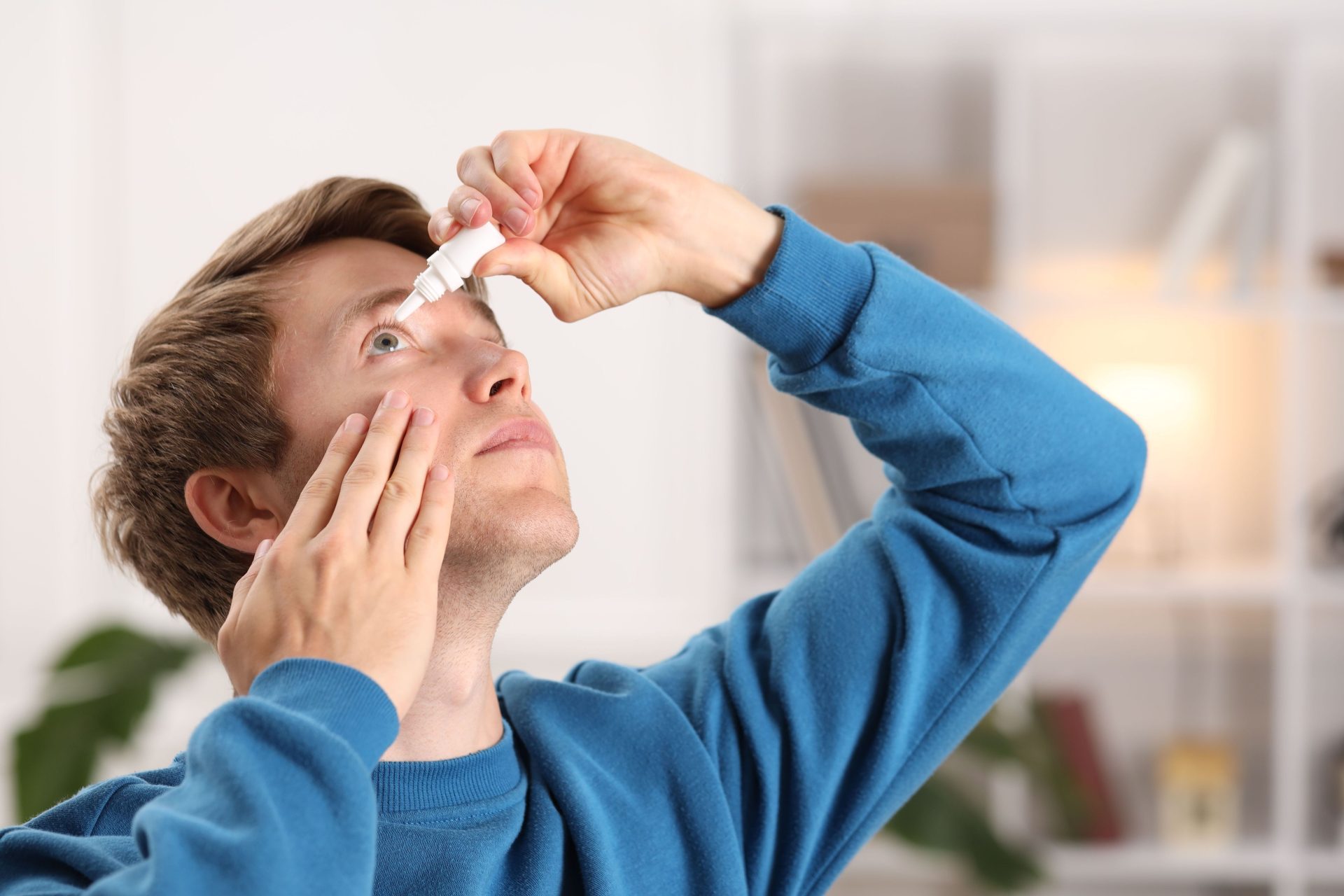 giovane uomo utilizza collirio per allergia agli occhi
