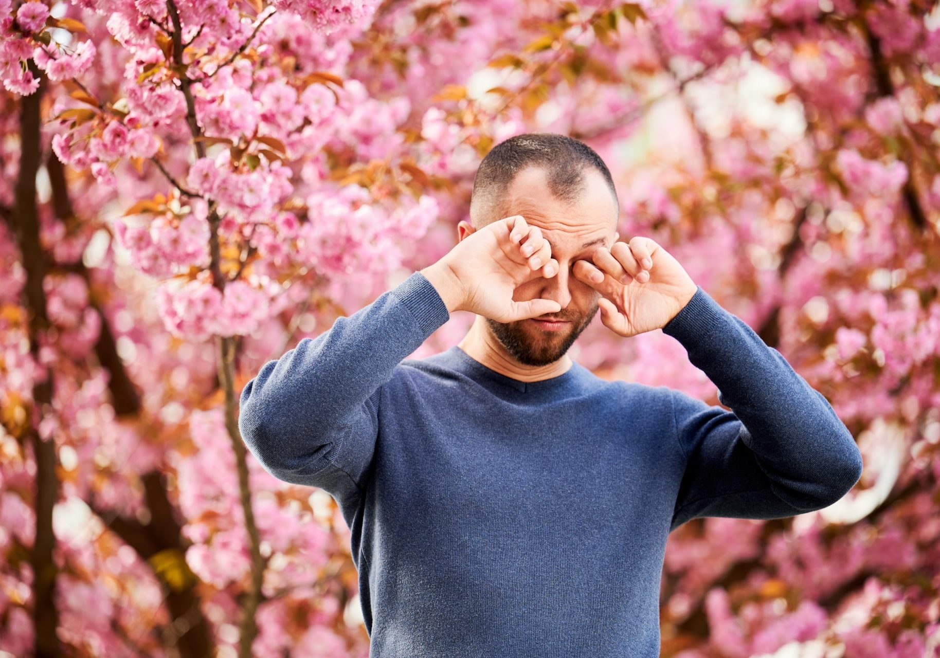 uomo con prurito agli occhi per allergia ai pollini