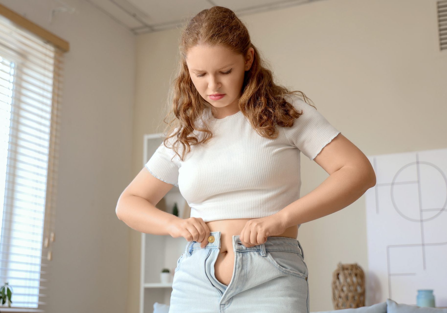 ragazza fatica a indossare paio di jeans