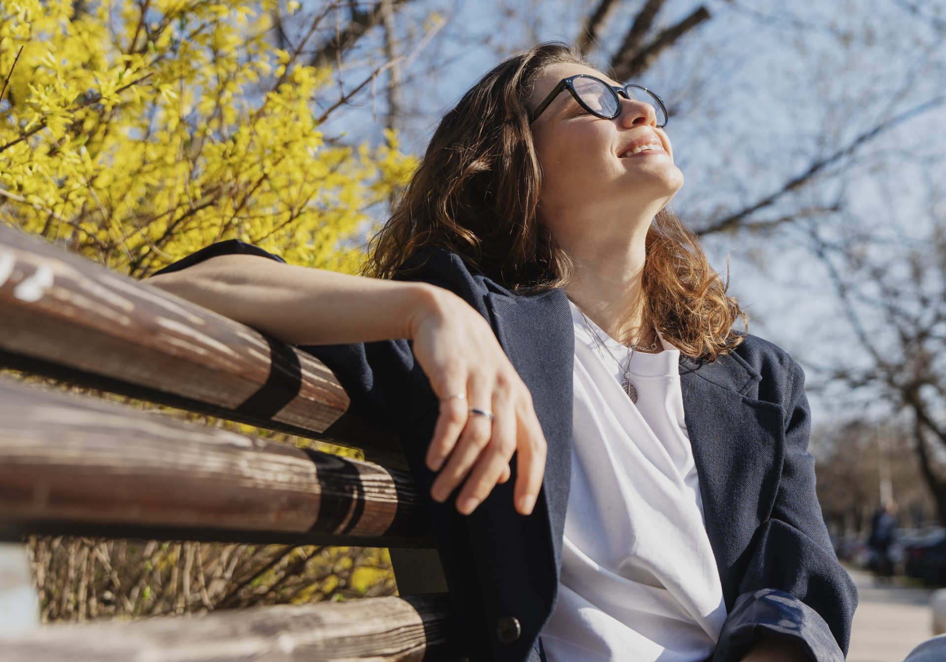 giovane donna seduta su una panchina al sole