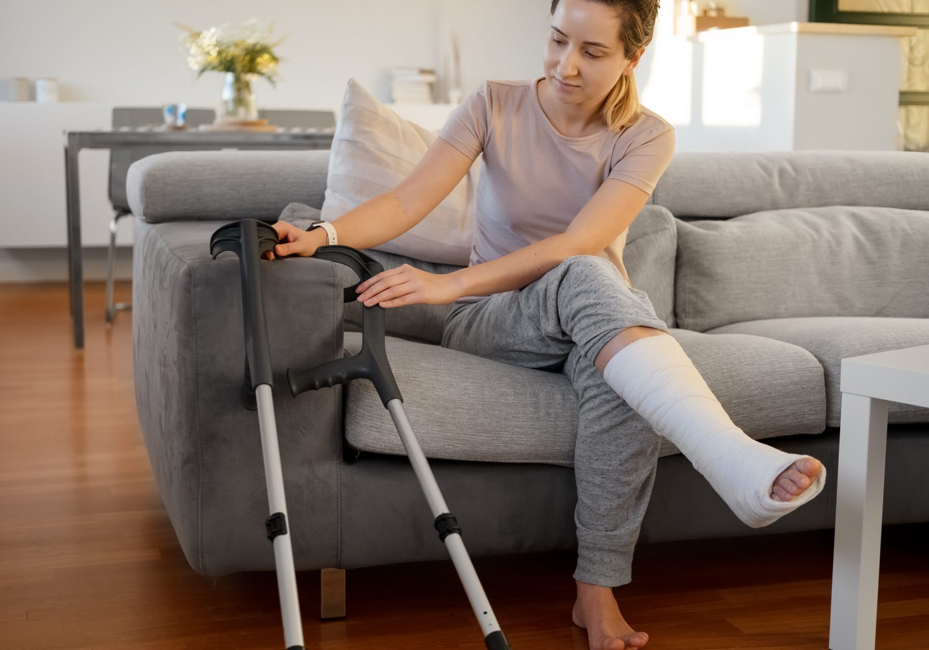 donna con gamba ingessata seduta sul divano