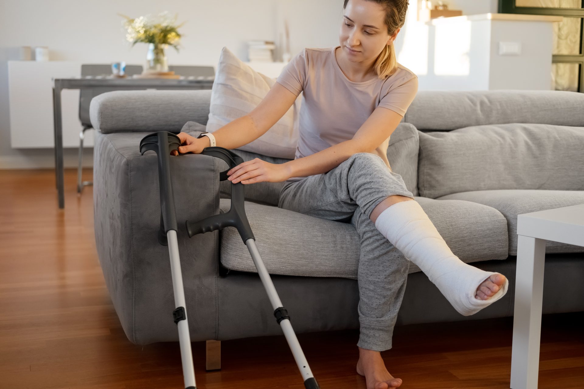 donna con gamba ingessata seduta sul divano
