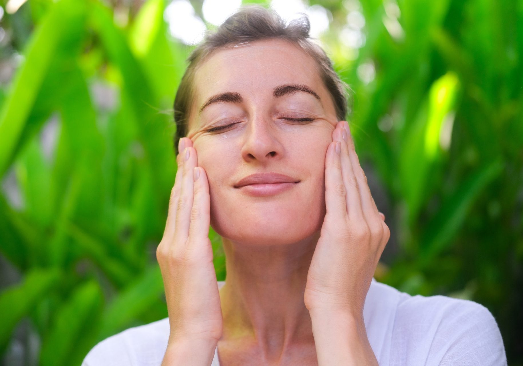 pelle-primavera donna si tocca il viso all'aperto