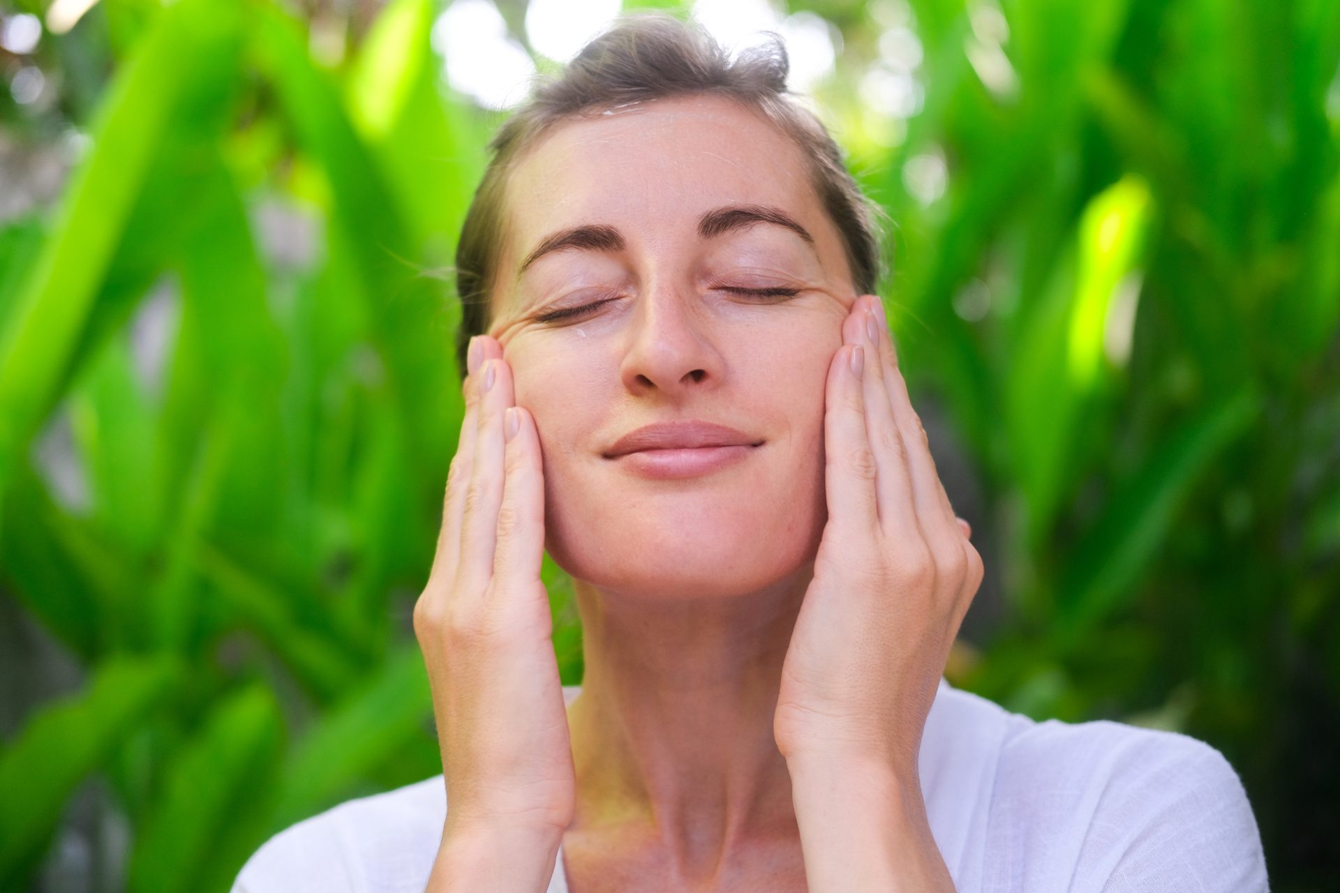 donna si tocca il viso all'aperto