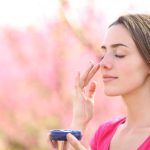 giovane donna applica protezione solare all'aperto