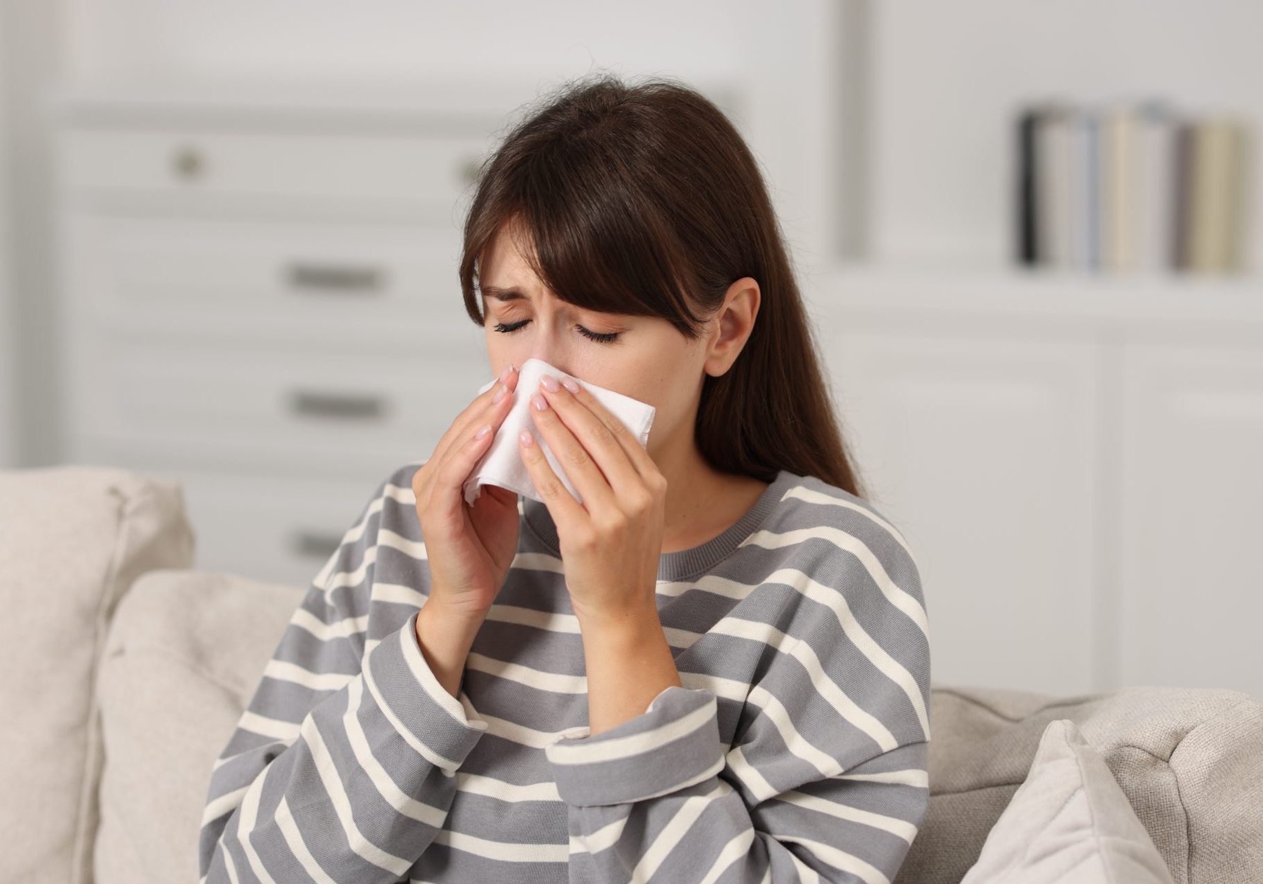 donna con rinite allergica si soffia il naso