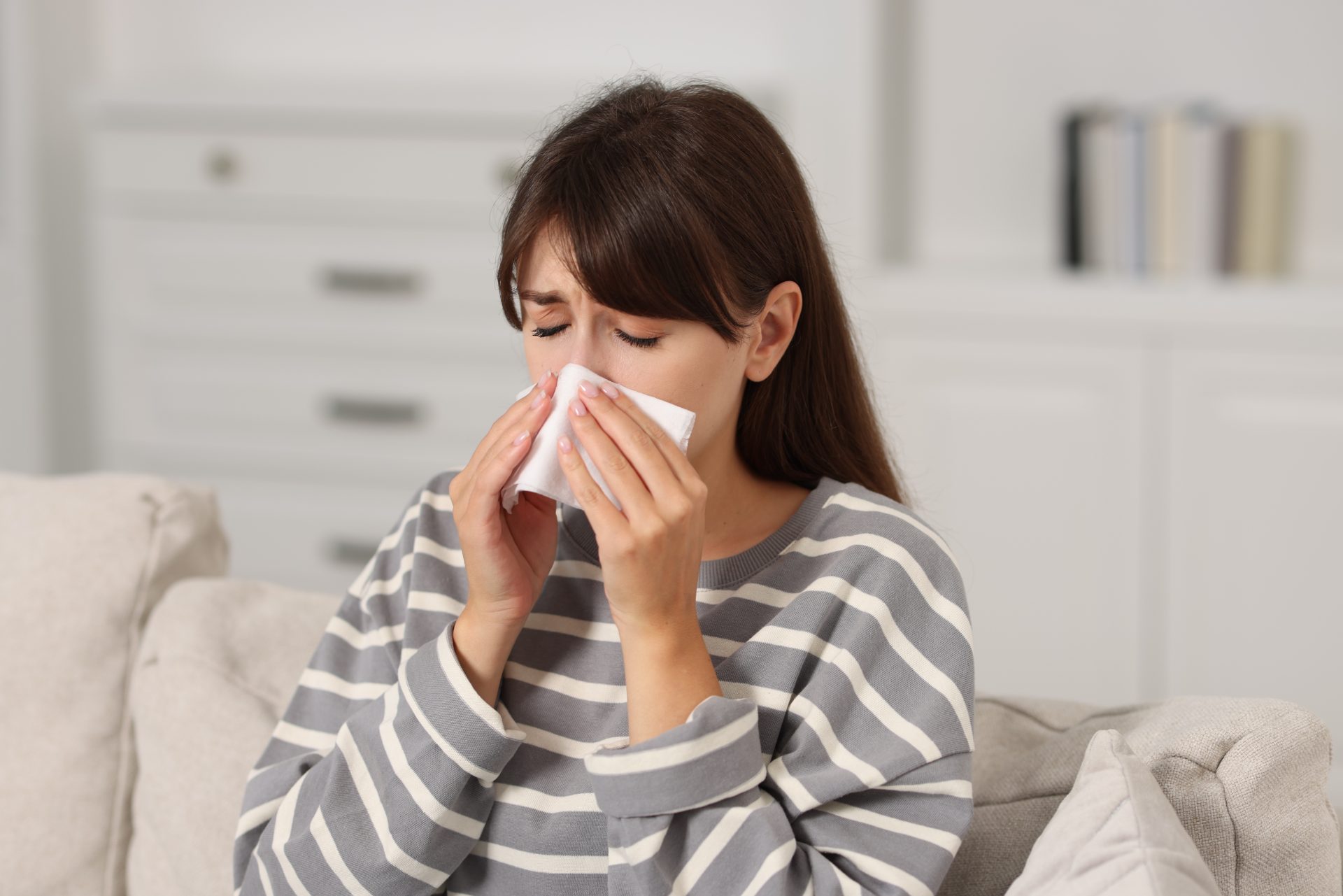 donna con rinite allergica si soffia il naso