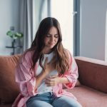 ragazza seduta sul divano con attacco di panico