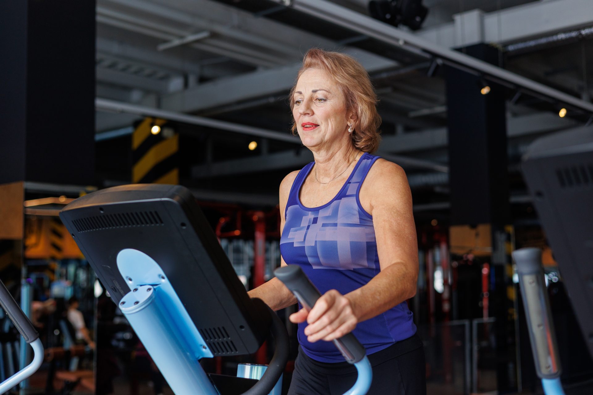 donna anziana su ellittica in palestra