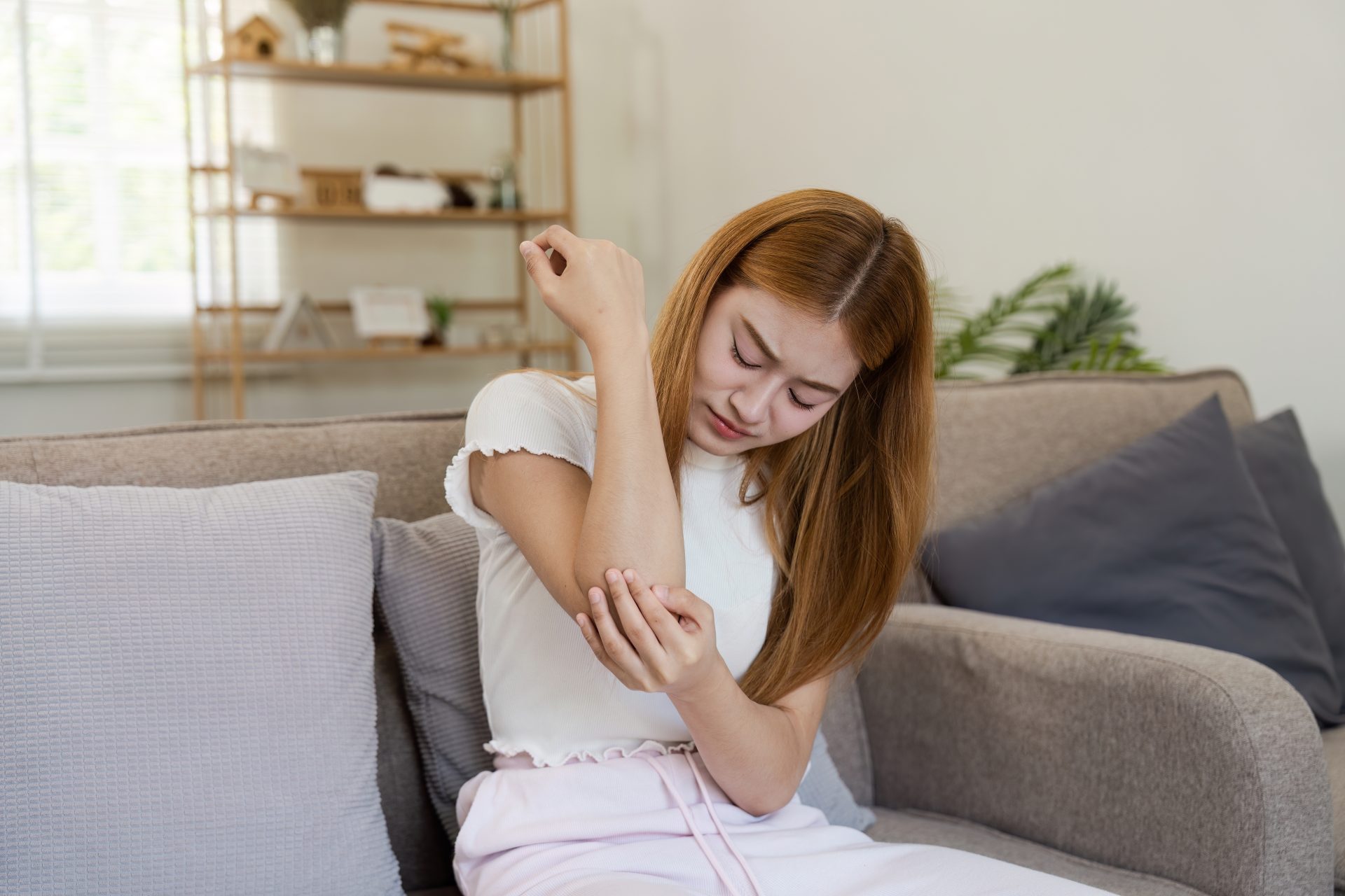 donna con prurito al gomito causato da psoriasi