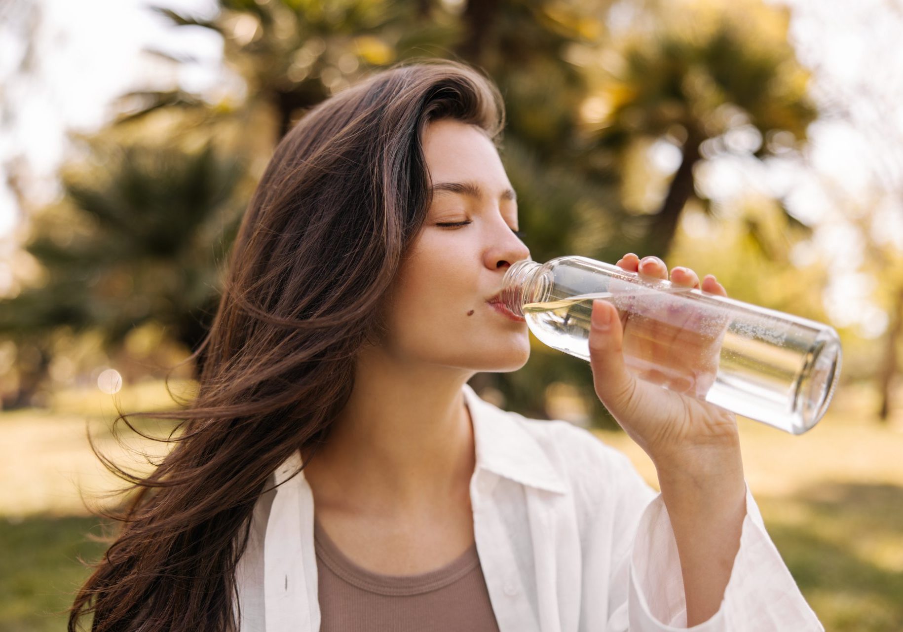 giovane donna beve acqua all'aperto