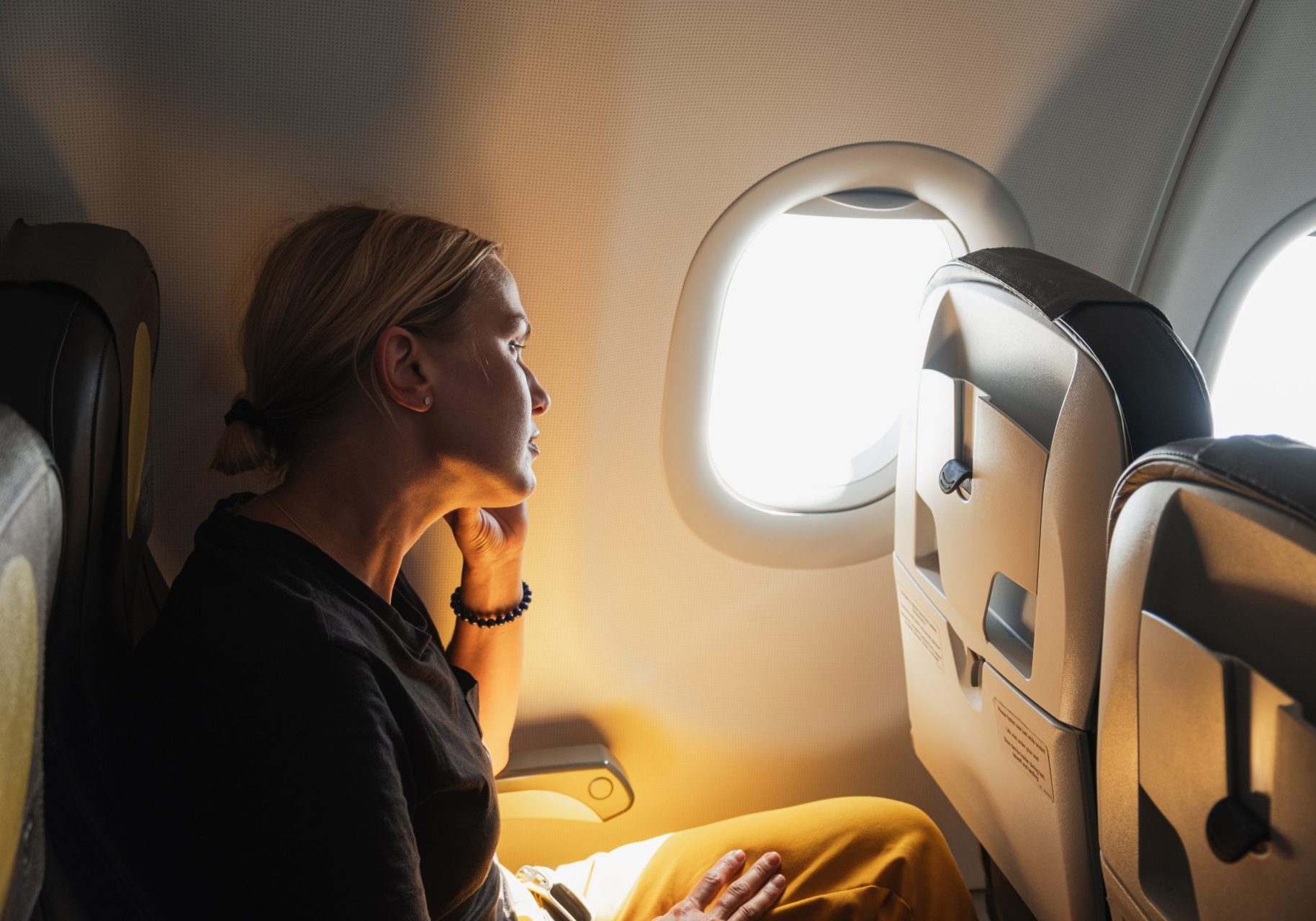 donna seduta in aereo guarda dal finestrino