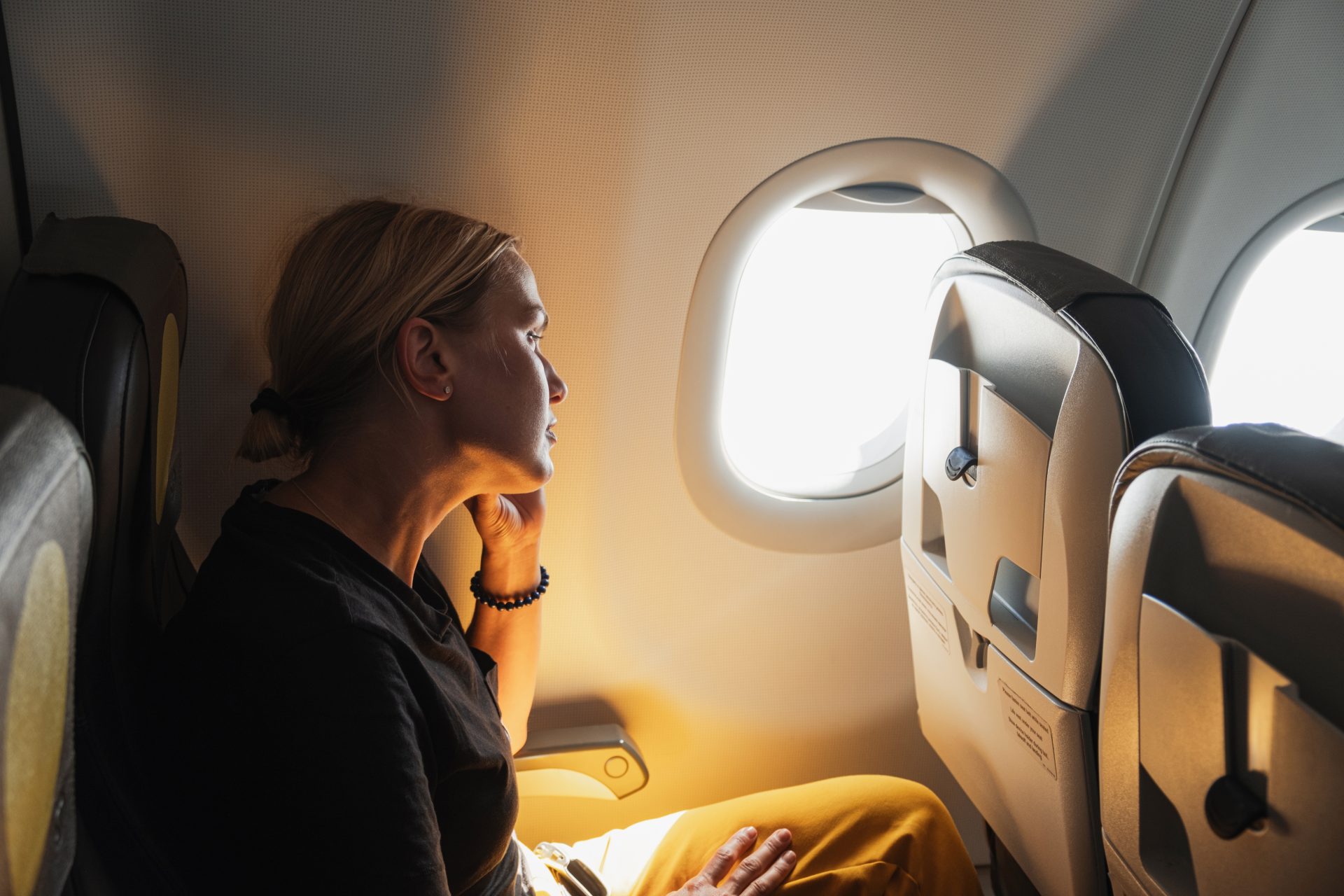 donna seduta in aereo guarda dal finestrino
