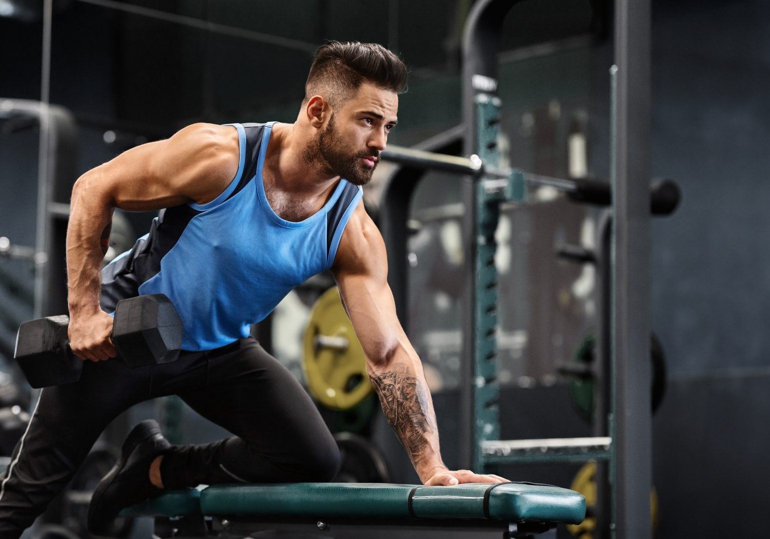 giovane uomo si allena con pesi in palestra