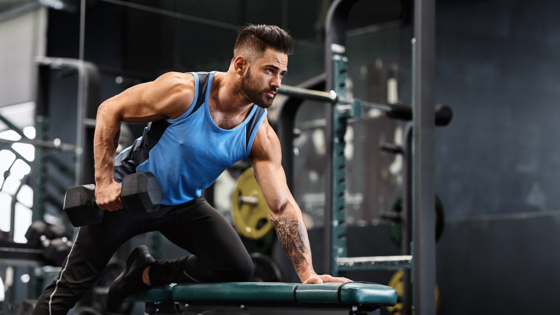 giovane uomo si allena con pesi in palestra
