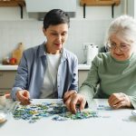 caregiver costruisce puzzle con anziana