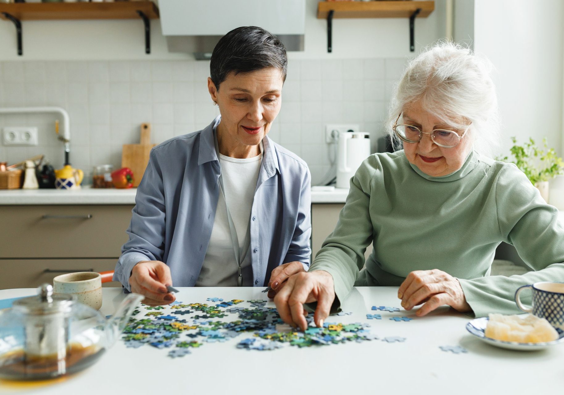 caregiver costruisce puzzle con anziana