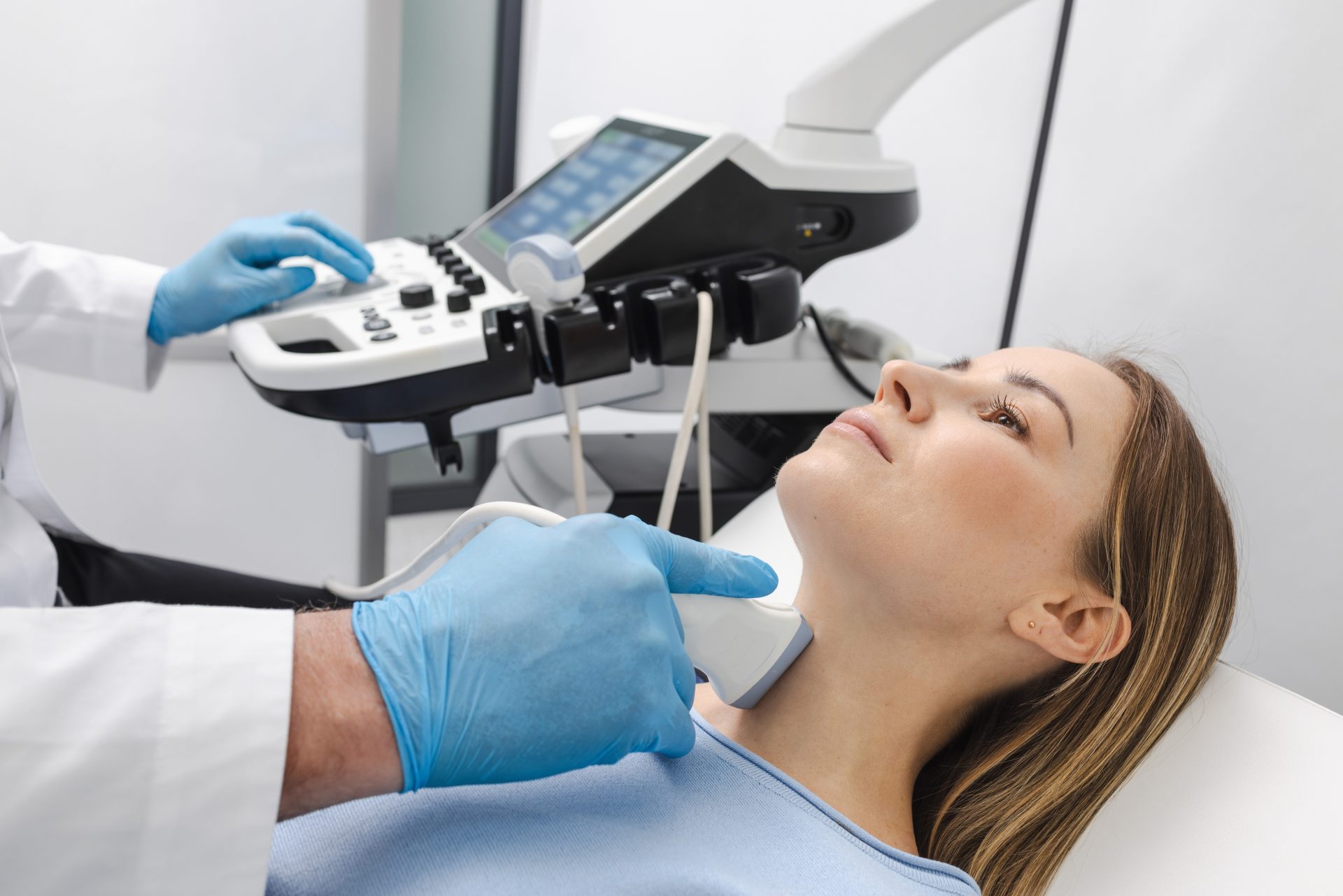 medico esegue ecografia tiroidea su paziente