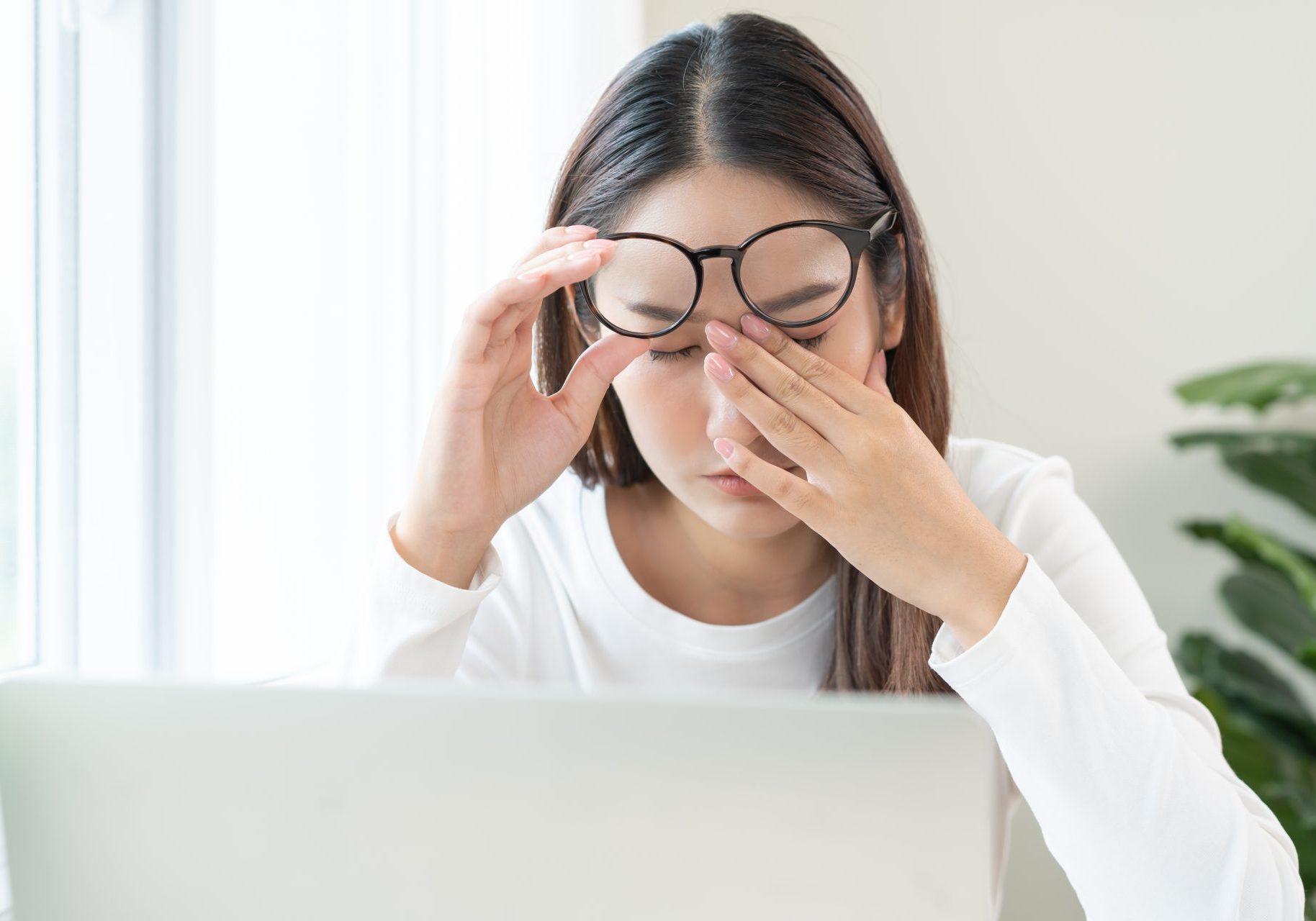 giovane donna davanti al computer strofina gli occhi