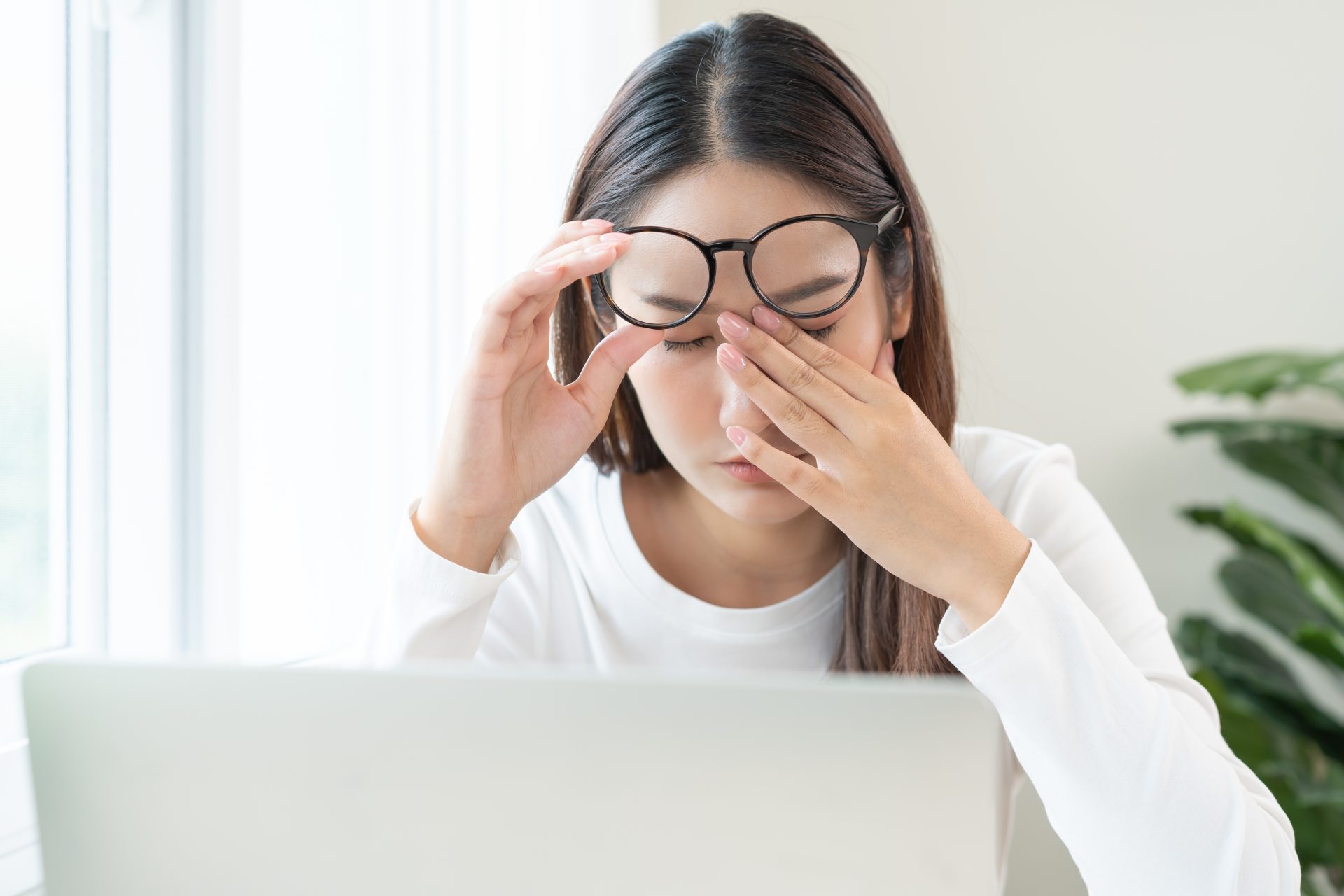 giovane donna davanti al computer strofina gli occhi